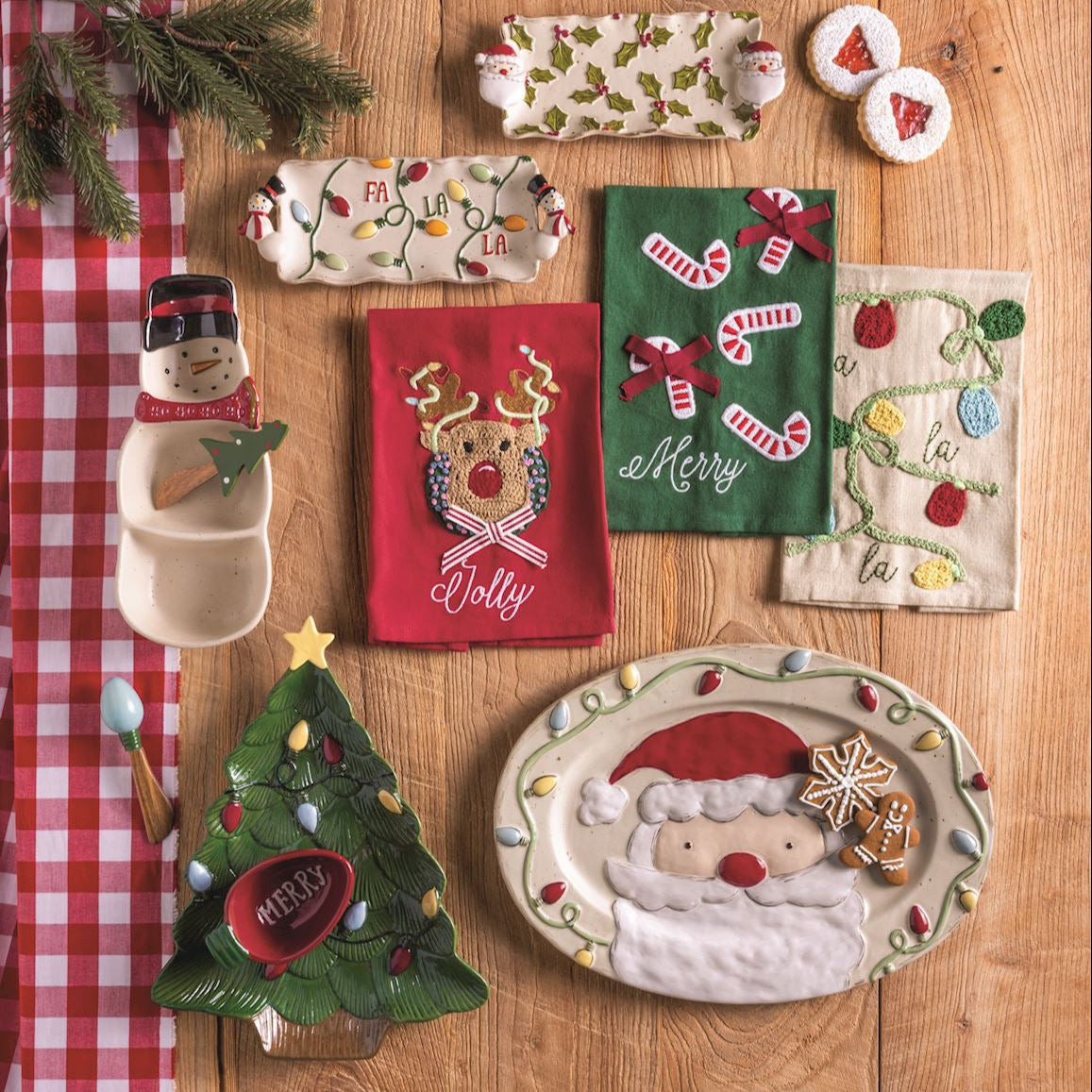 Collection of Christmas-themed decorative items on a wooden surface with a red checkered cloth.