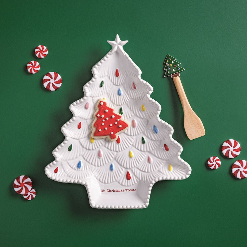 Decorative Christmas tree plate with candy on a green background