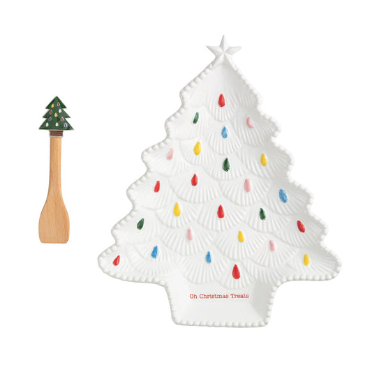 Christmas tree-shaped plate with colorful lights and a wooden spoon on a white background