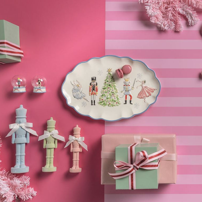 Decorative items including plates, gift boxes, and ornaments on a pink striped background