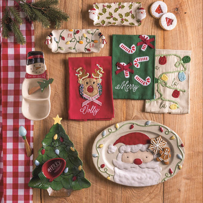Collection of Christmas-themed decorative items on a wooden surface with a red checkered cloth.