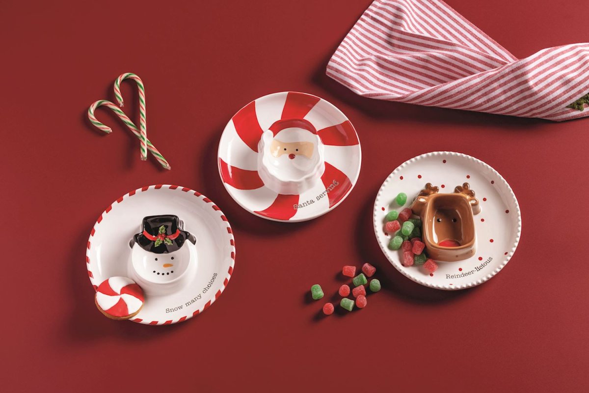Three decorative Christmas plates with candy cane, snowman, and reindeer designs on a red background.