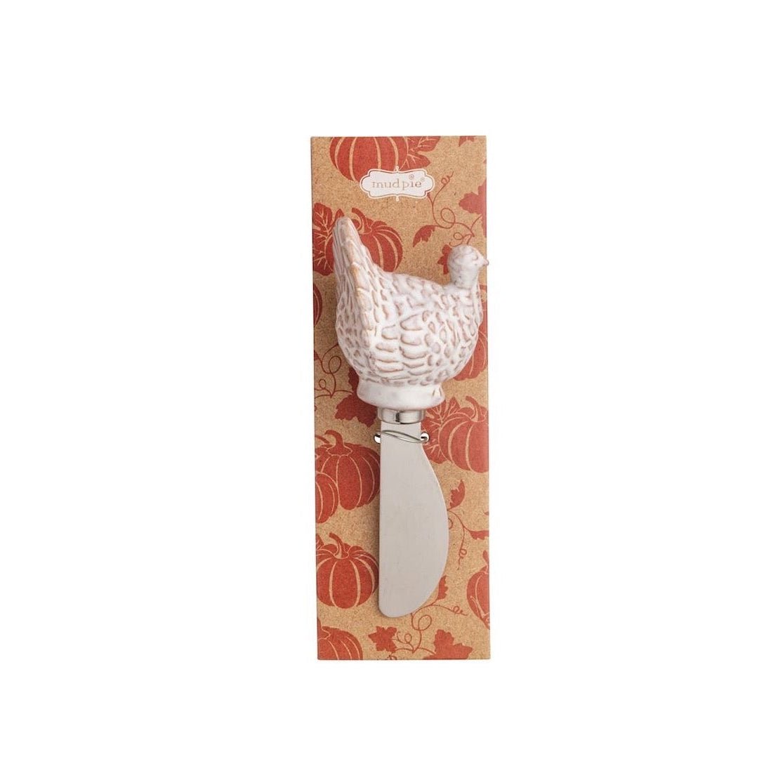 A decorative cheese knife with a carved turkey-shaped handle, mounted on a vertical retail card featuring a pumpkin pattern, set against a plain white background.