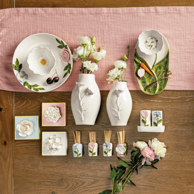 Table setting with decorative items, including vases, plates, and towels on a wooden table.